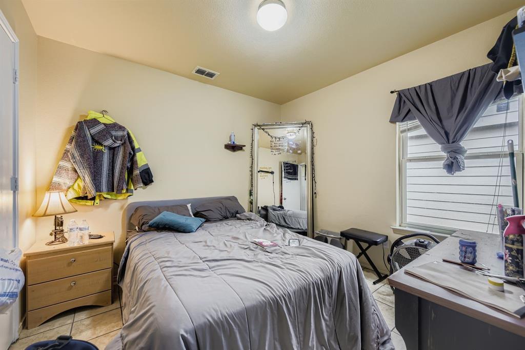 2228 Sims Drive Fort Worth, TX 76119 - Photo 11 of 15 a bedroom with a bed and a dresser