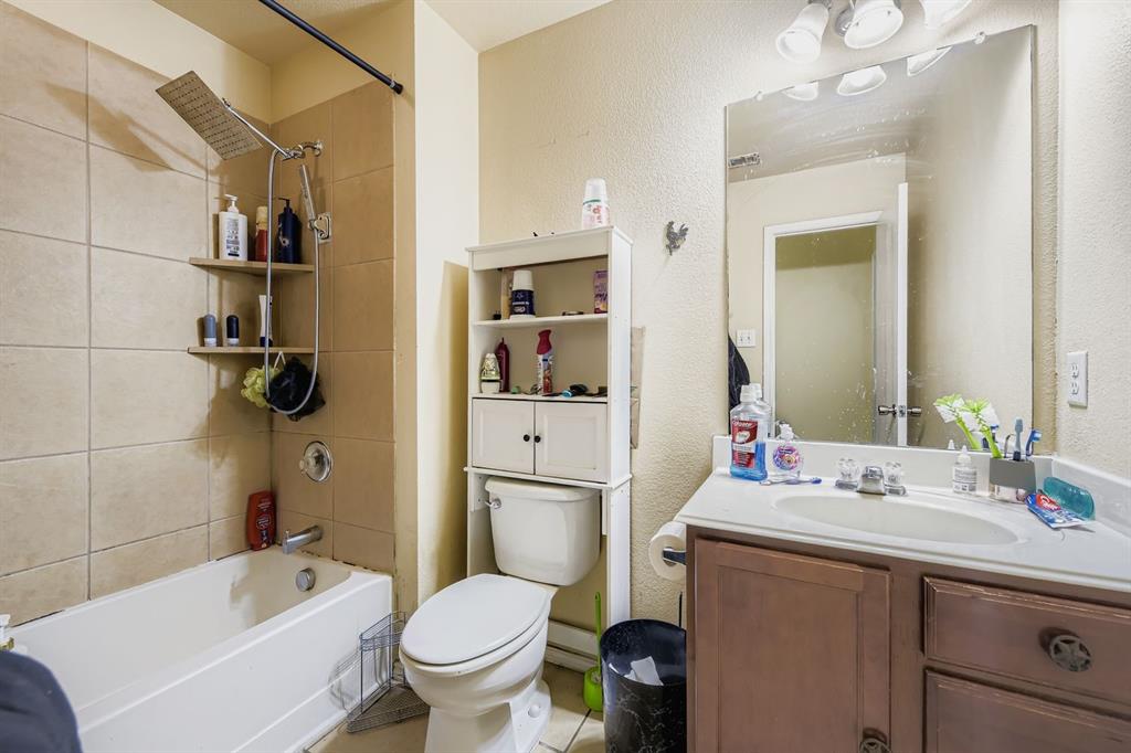 2228 Sims Drive Fort Worth, TX 76119 - Photo 14 of 15 a bathroom with a sink toilet vanity granite tub and shower