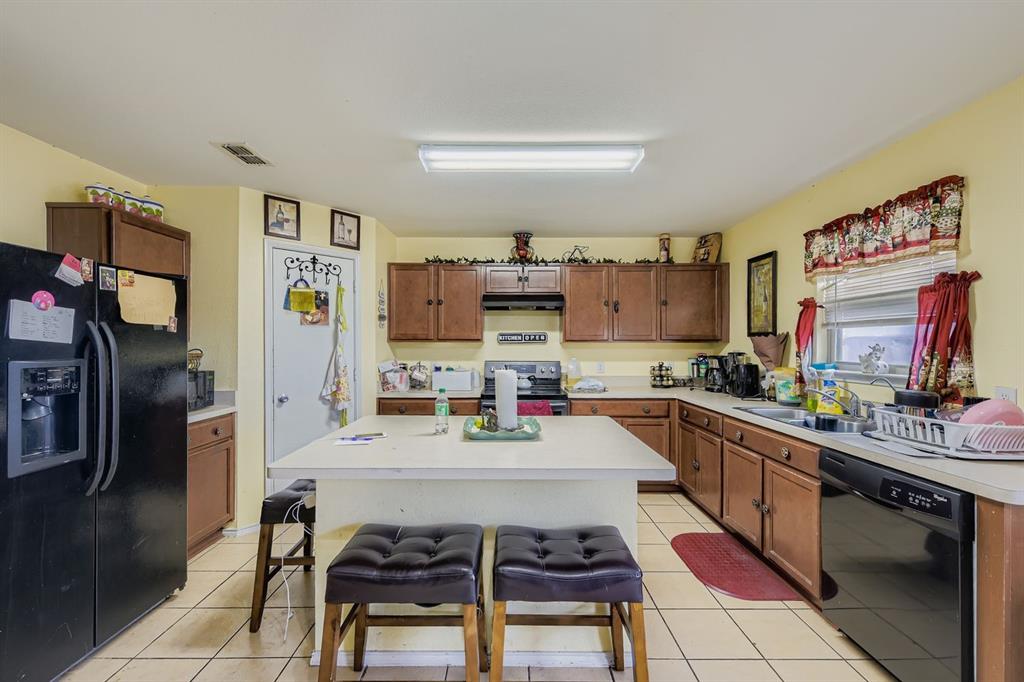 2228 Sims Drive Fort Worth, TX 76119 - Photo 3 of 15 a kitchen with stainless steel appliances a sink and cabinets