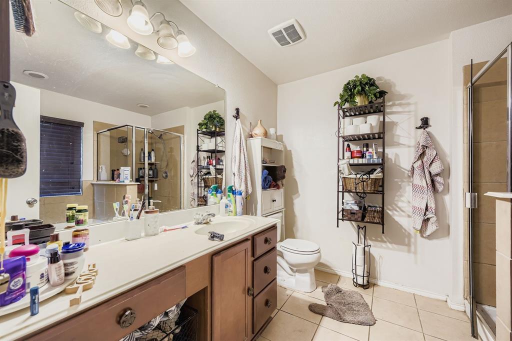 2228 Sims Drive Fort Worth, TX 76119 - Photo 10 of 15 a bathroom with a double vanity sink toilet and shower