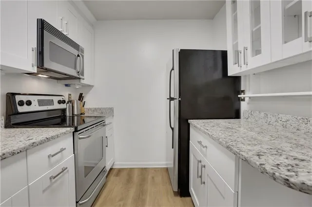a kitchen with granite countertop a refrigerator and a sink