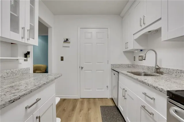 a kitchen with granite countertop a sink and a refrigerator