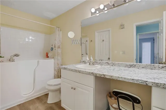 a bathroom with a granite countertop sink a toilet and a mirror