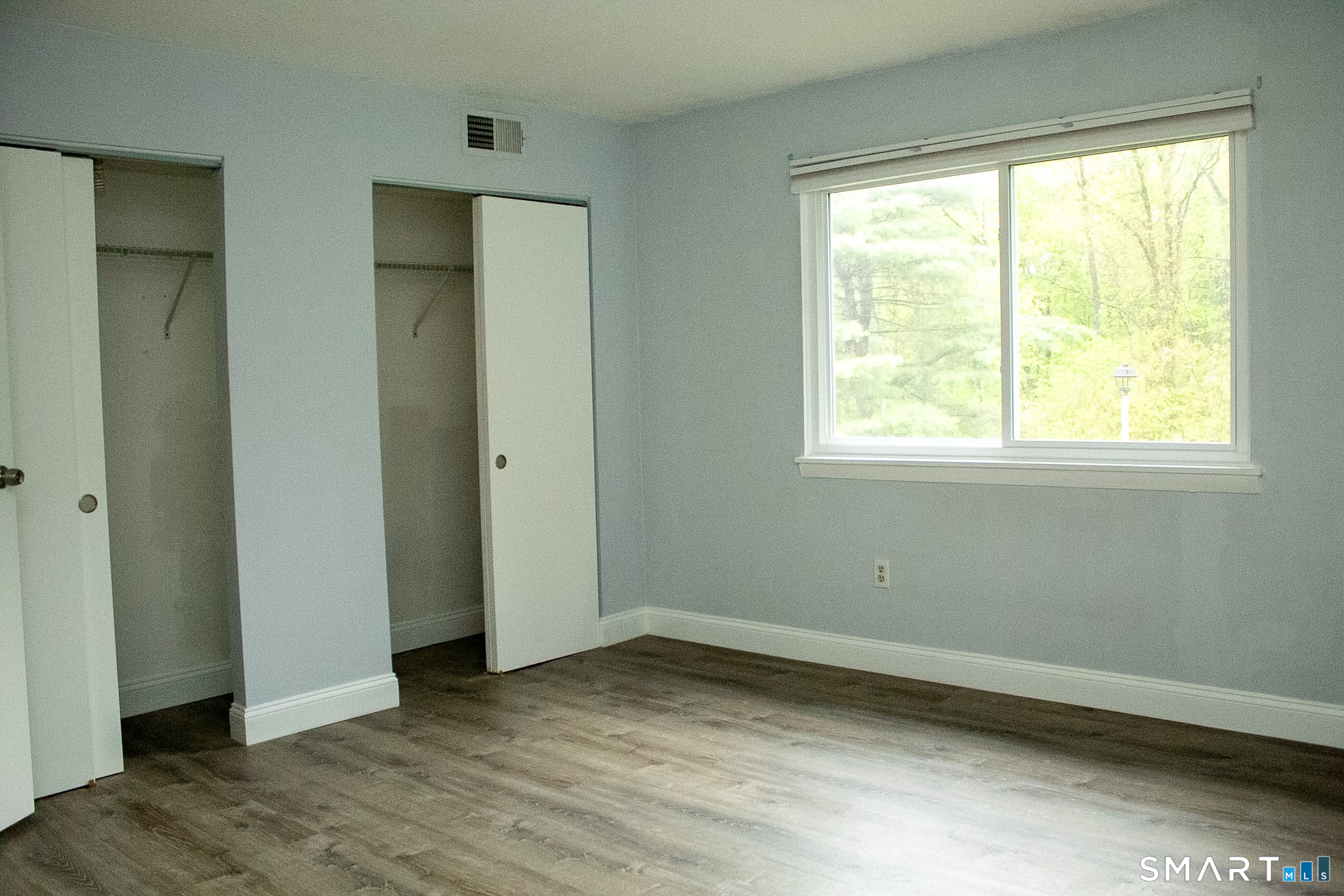 10 Georgetown Drive, Unit J Enfield, CT 06082 - Photo 12 of 15 an empty room with wooden floor and windows