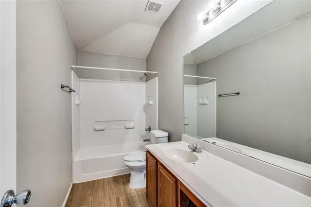 a bathroom with a sink toilet vanity and shower