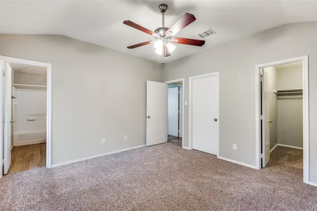 a view of an empty room with a ceiling fan