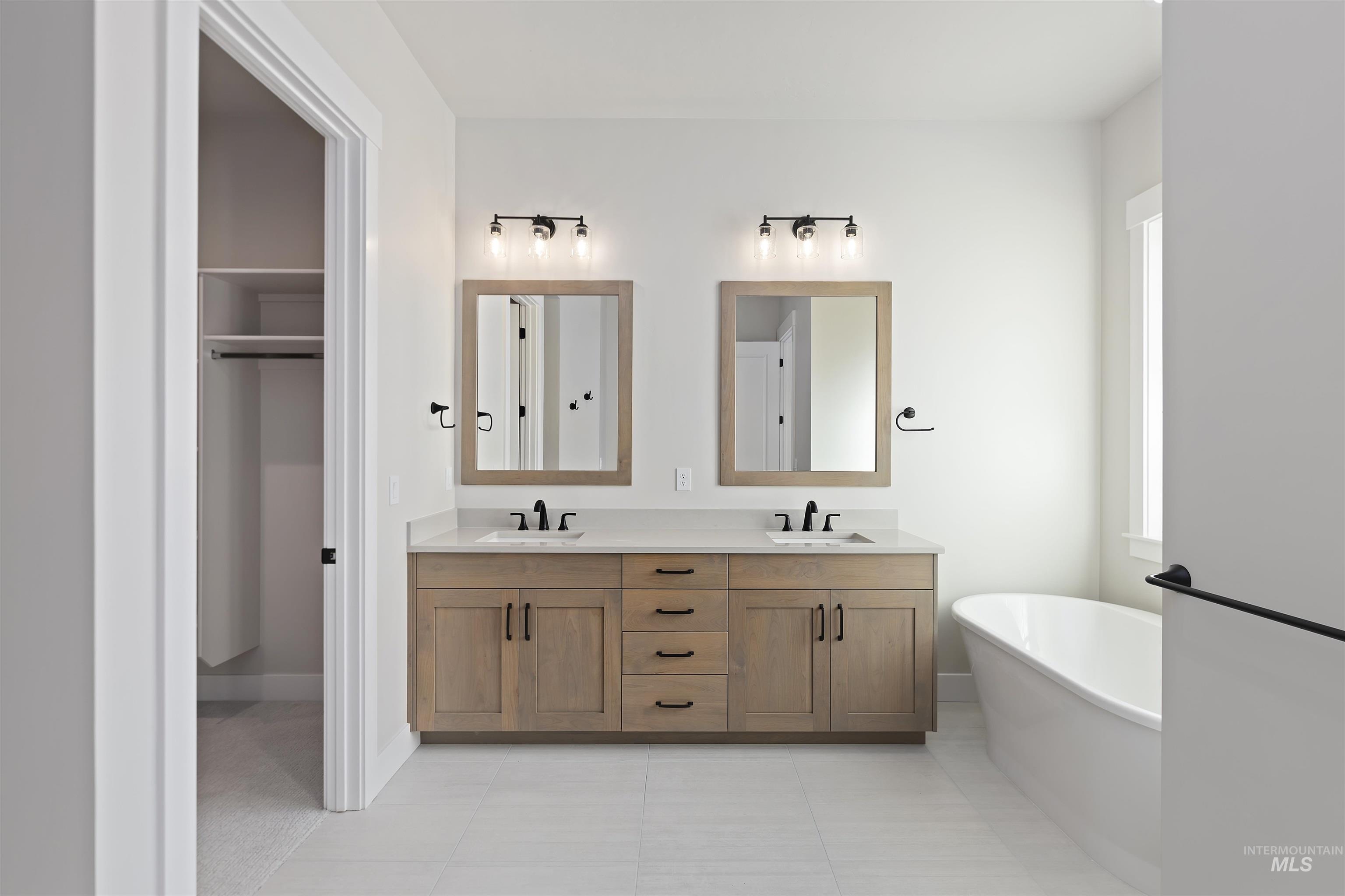 2247 East Blakehurst Street Kuna, ID 83634 - Photo 13 of 27 Full bath with a freestanding bath, double vanity, light tile patterned floors, and a walk in closet