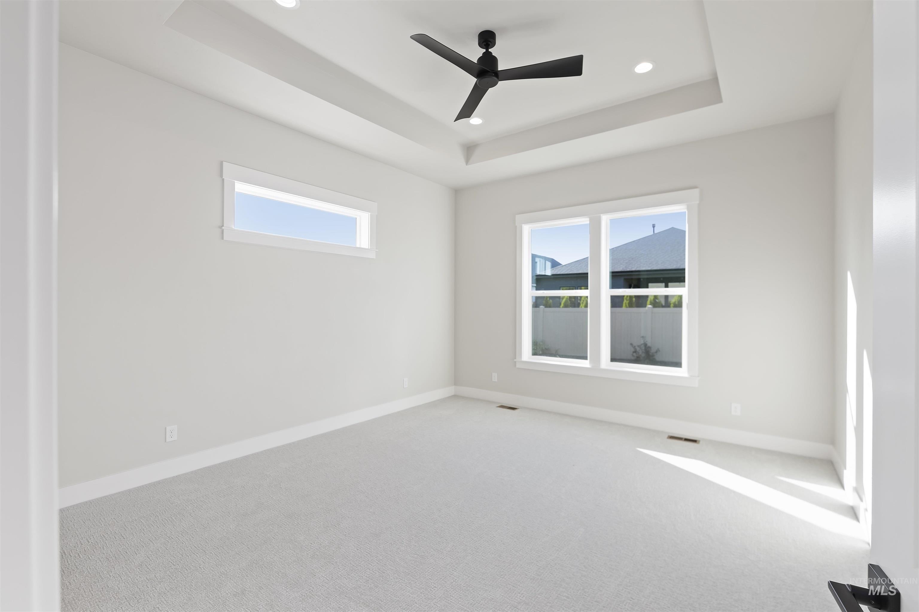 2247 East Blakehurst Street Kuna, ID 83634 - Photo 15 of 27 Carpeted spare room featuring a tray ceiling, ceiling fan, healthy amount of natural light, and recessed lighting