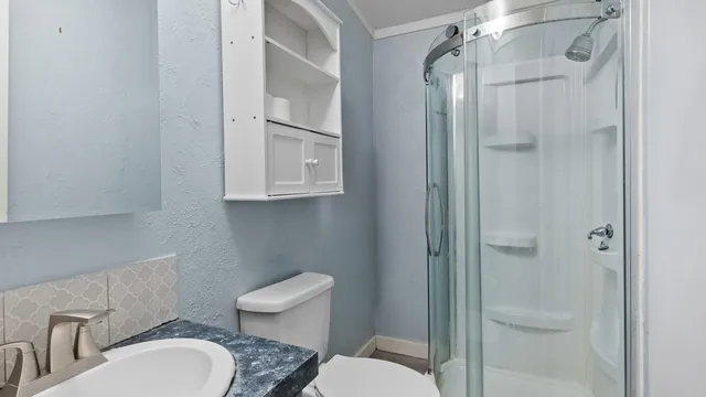 a bathroom with a toilet a sink and shower