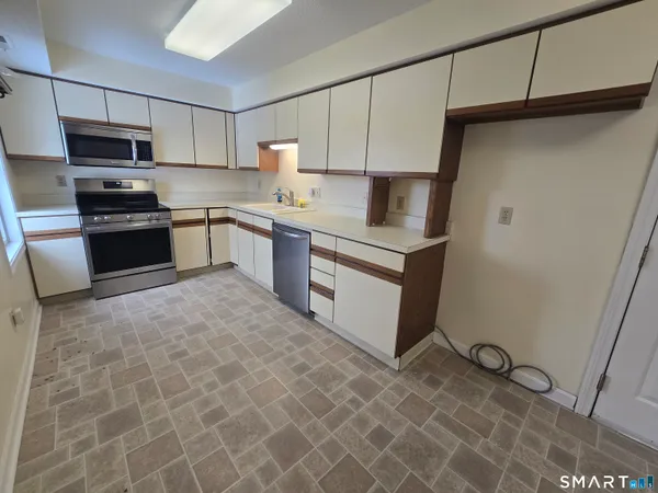 a kitchen with stainless steel appliances a refrigerator sink and microwave
