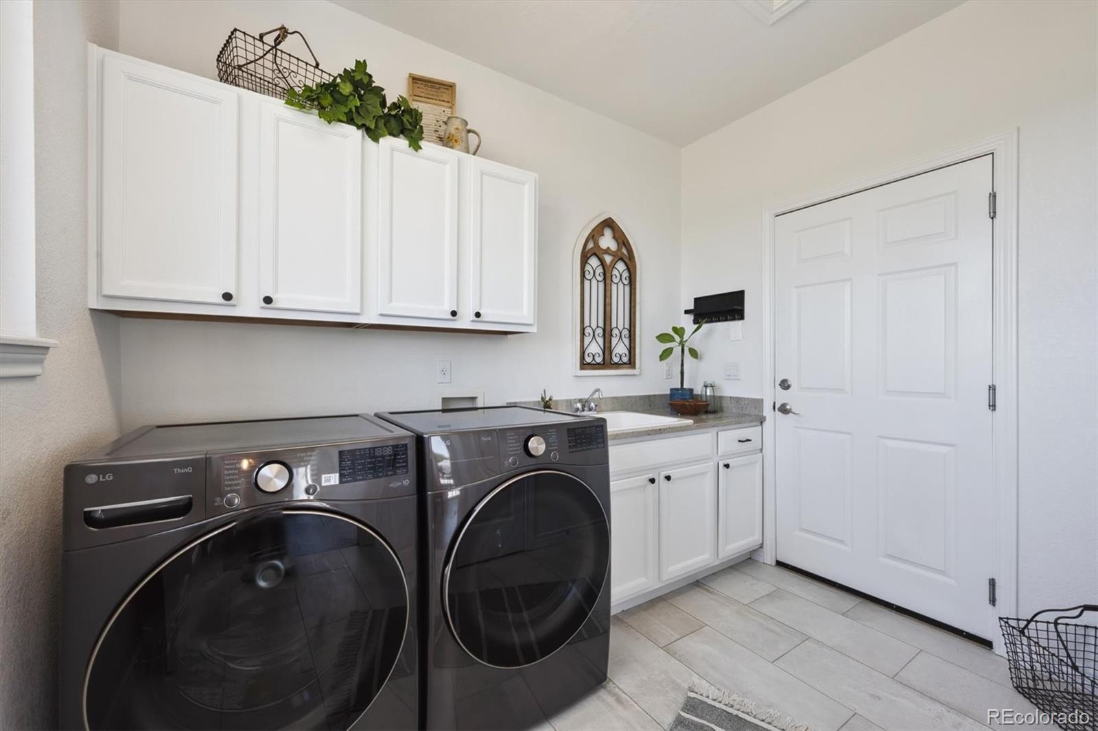 724 Imboden Road Watkins, CO 80137 - Photo 16 of 50 a utility room with sink dryer and washer