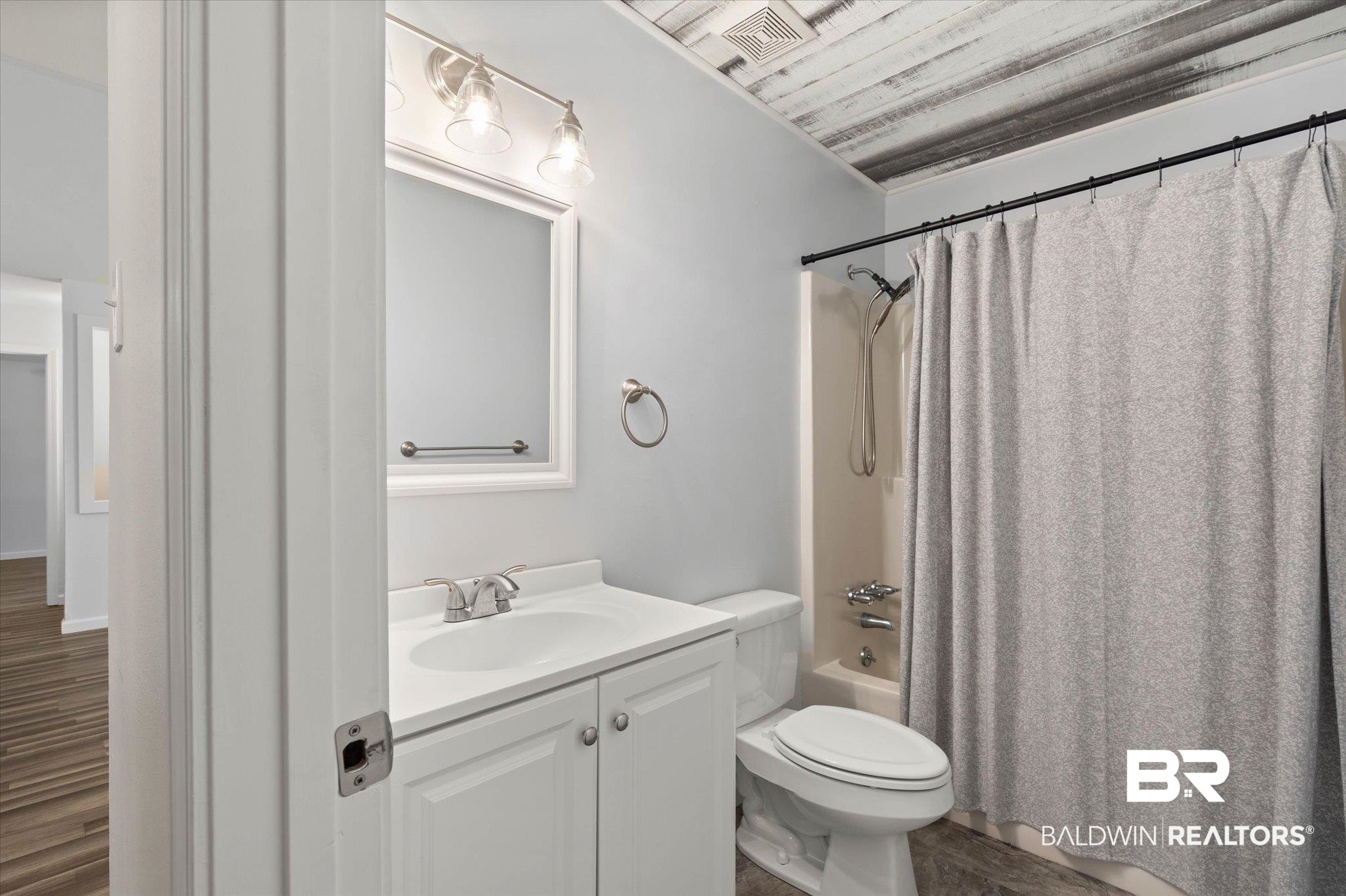123 Richmond Road Daphne, AL 36526 - Photo 17 of 35 Full bathroom featuring vanity, shower / bathtub combination with curtain, and wood finished floors