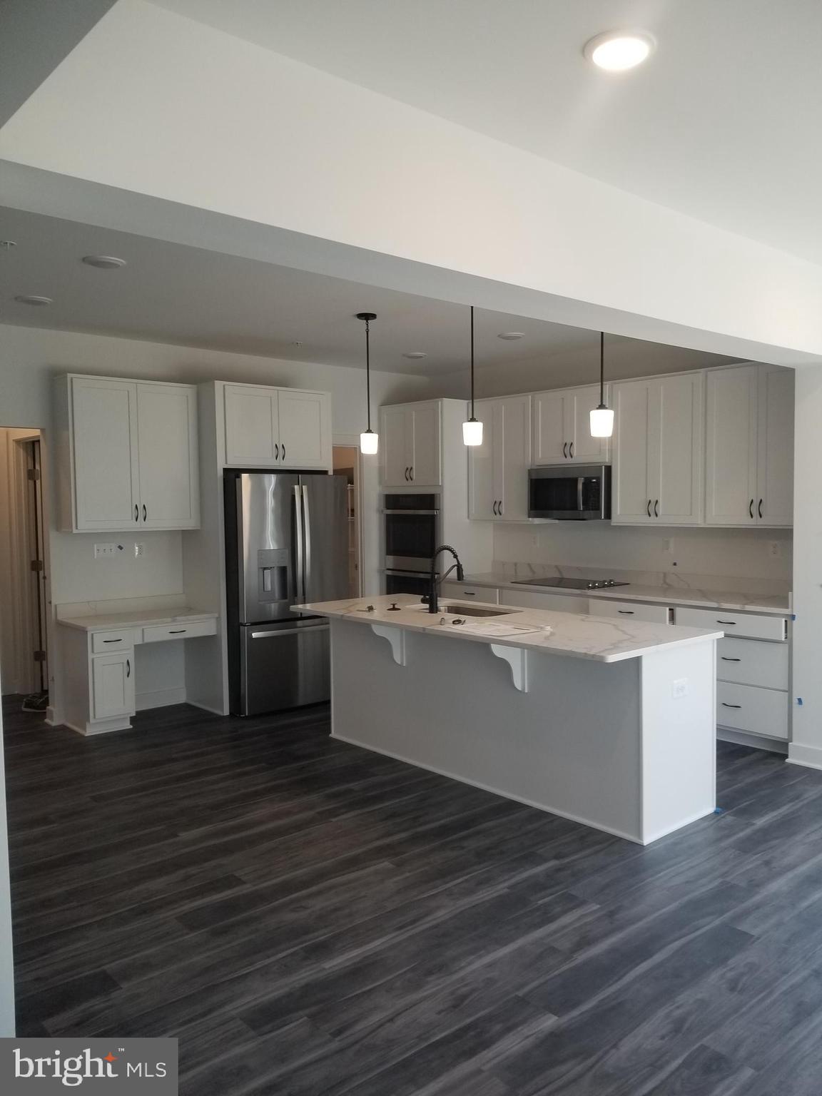 4747 Bryantown Road Waldorf, MD 20601 - Photo 33 of 62 a large kitchen with stainless steel appliances kitchen island a sink dishwasher a refrigerator and a stove with wooden floors