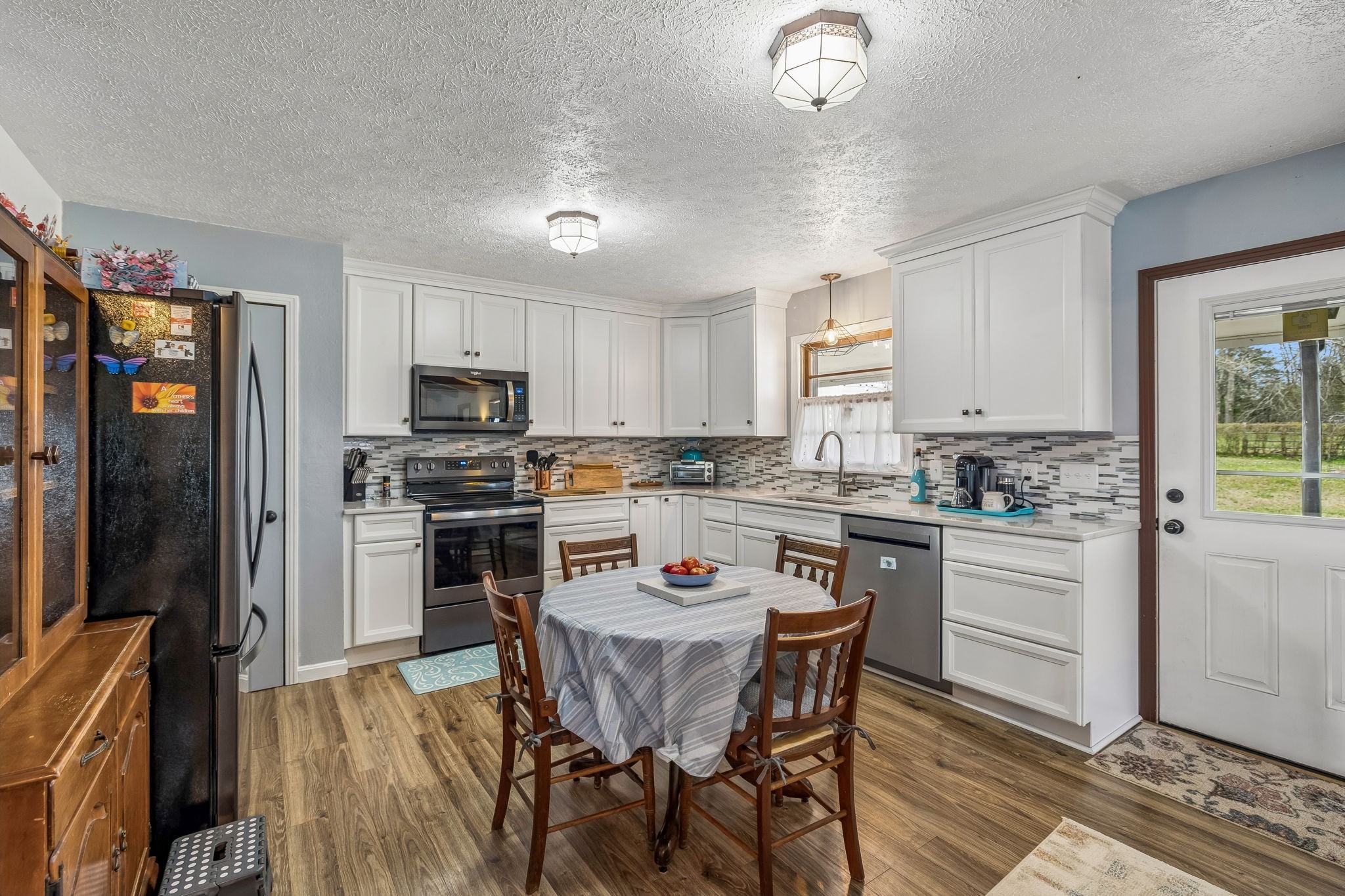 6200 Pinewood Road Nunnelly, TN 37137 - Photo 49 of 57 a kitchen with a refrigerator a stove a sink a dining table and chairs