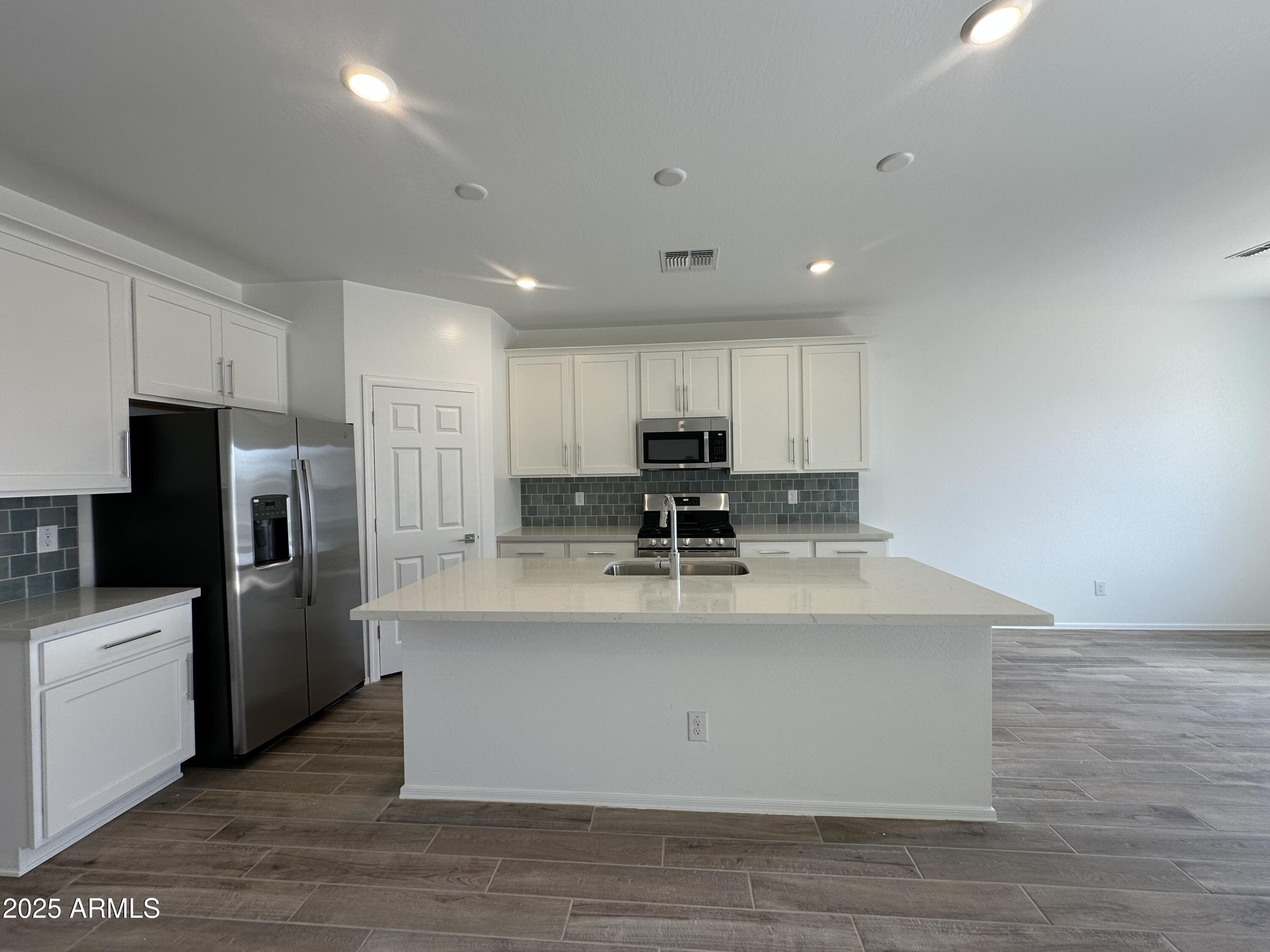 47691 West Moeller Road Maricopa, AZ 85139 - Photo 12 of 31 a large kitchen with stainless steel appliances granite countertop a large counter top and a stove top oven