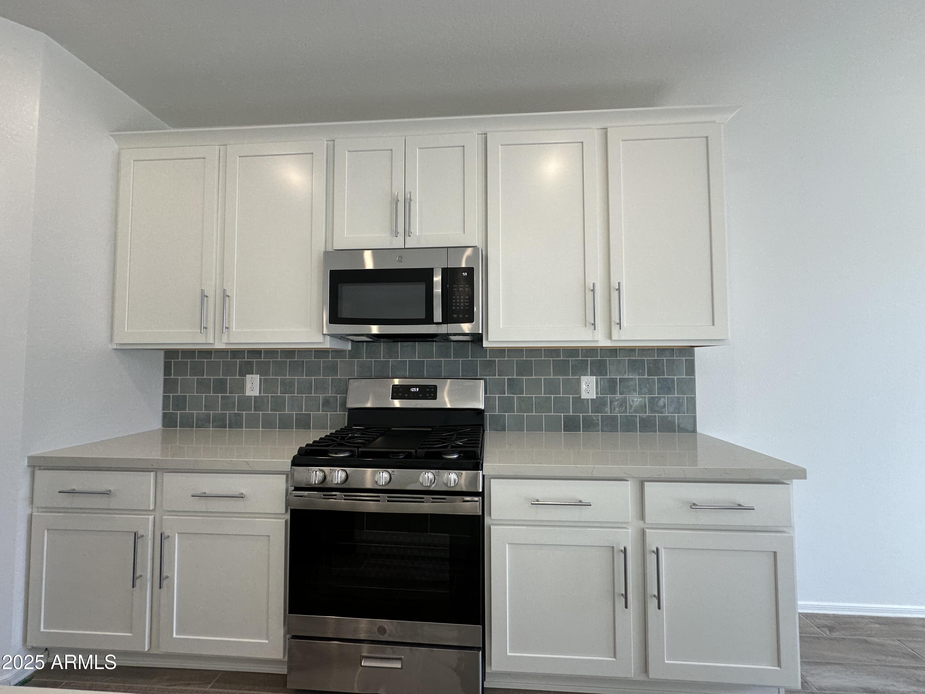 47691 West Moeller Road Maricopa, AZ 85139 - Photo 13 of 31 a kitchen with white cabinets and stainless steel appliances