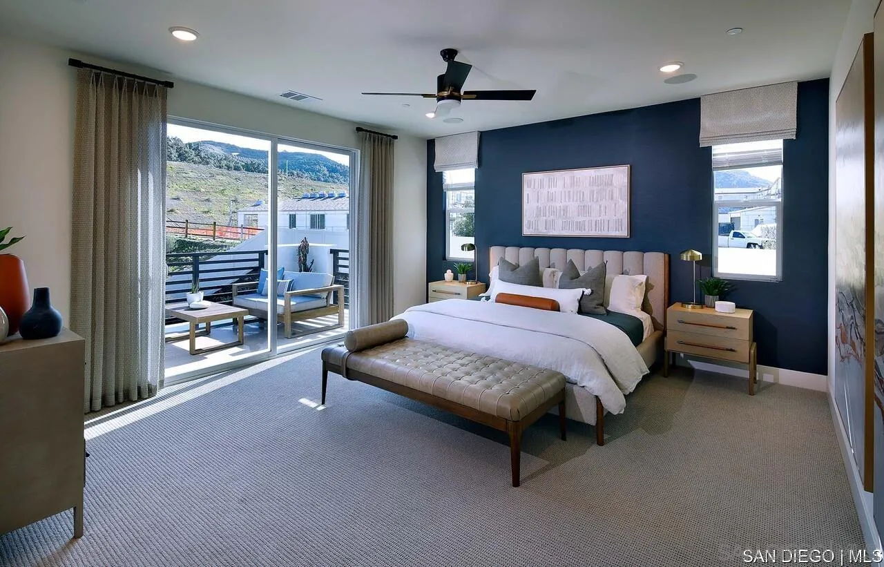 a spacious bedroom with a bed and glass walk in closet