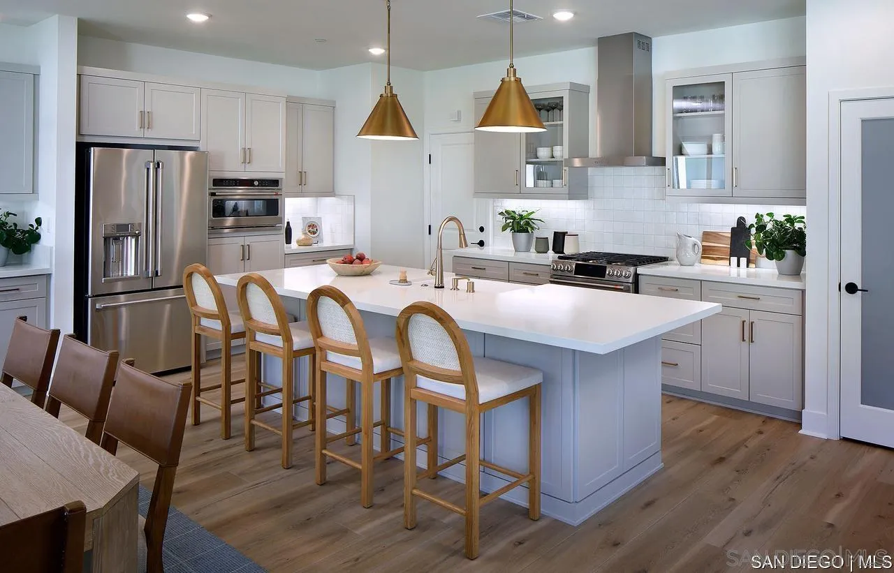 709 Meadowood Street, Unit 328 Fallbrook, CA 92028 - Photo 7 of 11 a kitchen with stainless steel appliances granite countertop a table chairs refrigerator and microwave