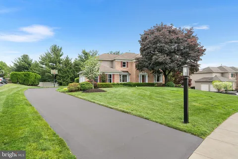 a view of a house with a big yard plants and large trees