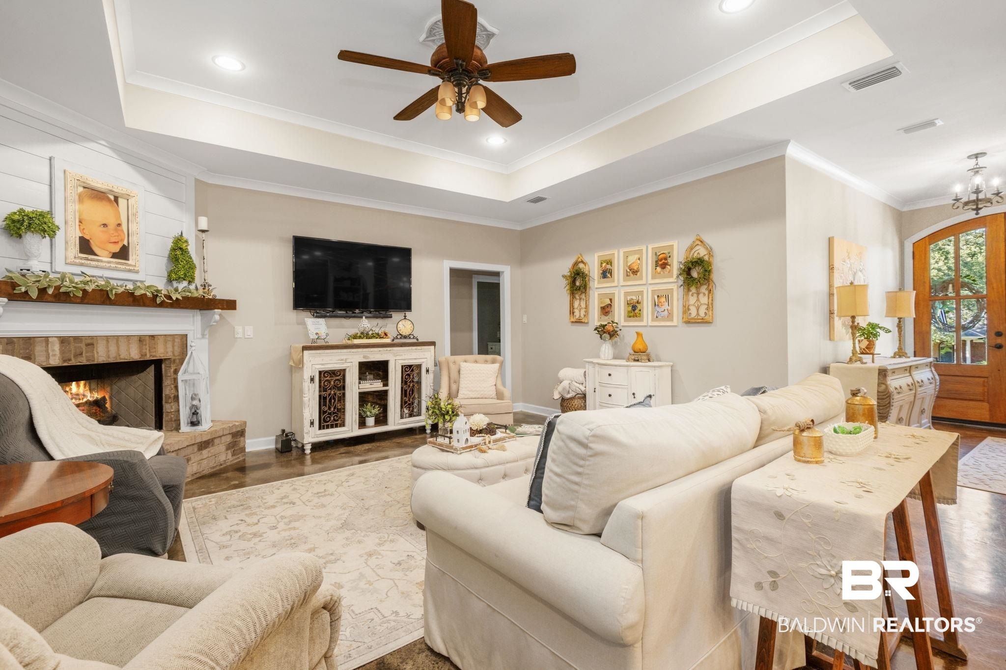 4331 Hamilton Oaks Lane Mobile, AL 36695 - Photo 7 of 38 Living room with a warm lit fireplace, ceiling fan, baseboards, a raised ceiling, and ornamental molding