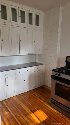 a kitchen with granite countertop white cabinets and stainless steel appliances