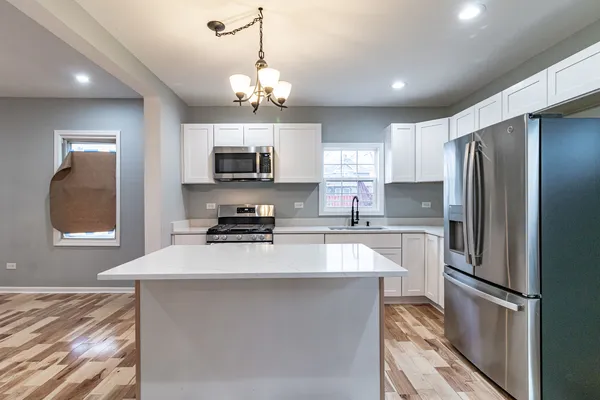 a kitchen with stainless steel appliances a refrigerator sink and microwave