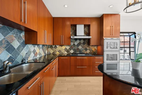 a kitchen with granite countertop a sink and a stove