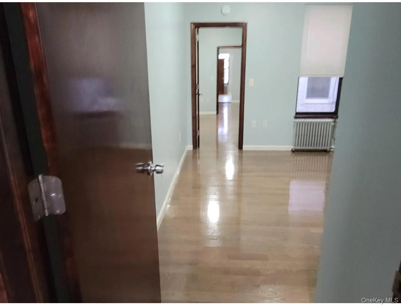 Undisclosed Address Queens, NY 11385 - Photo 6 of 6 a view of a hallway with wooden floor and a bathroom