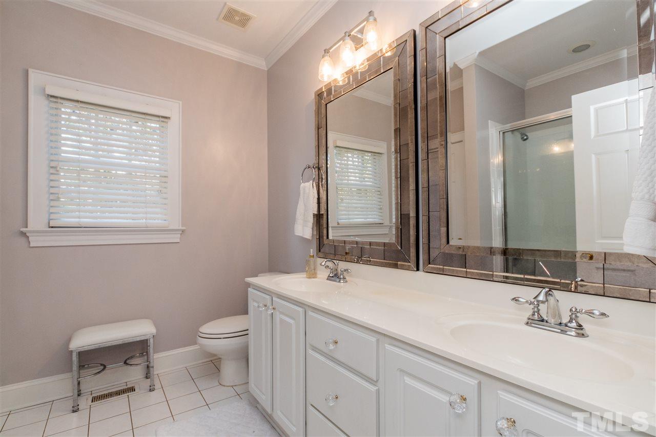 3205 Merriman Avenue Raleigh, NC 27607 - Photo 15 of 30 a bathroom with a double vanity sink a toilet and a mirror