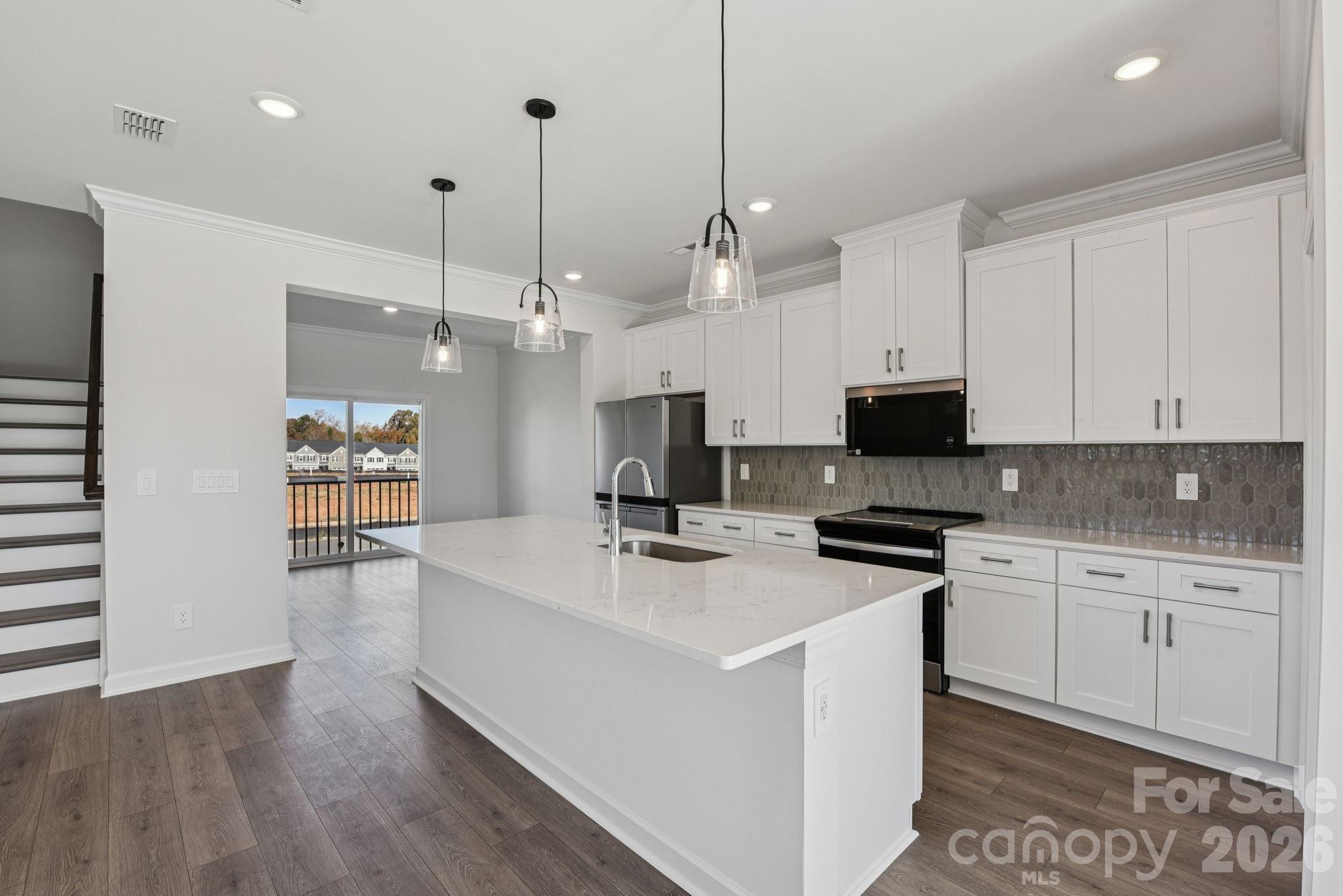 343 Golden Maple Court Fort Mill, SC 29708 - Photo 12 of 19 a kitchen with stainless steel appliances a stove a sink dishwasher a refrigerator and white cabinets with wooden floor