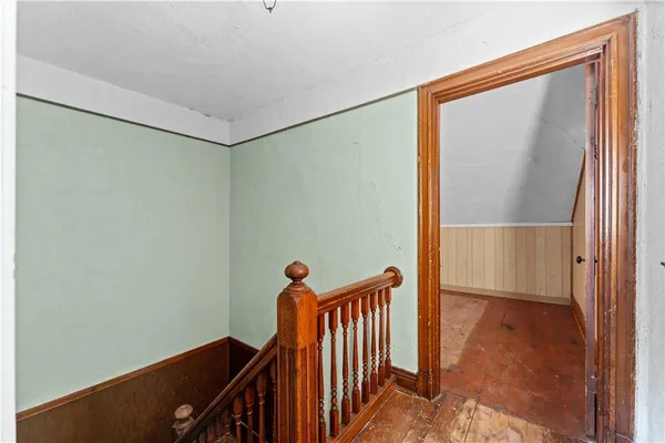 a view of a hallway with wooden floor and staircase