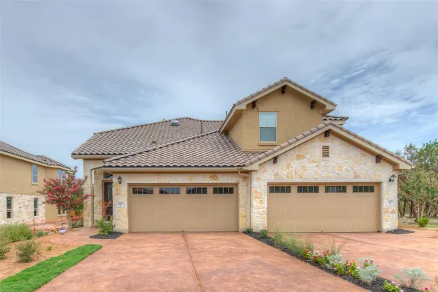 a front view of a house with a garden and yard