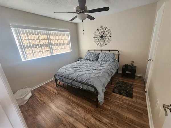 a bedroom with a bed and wooden floor
