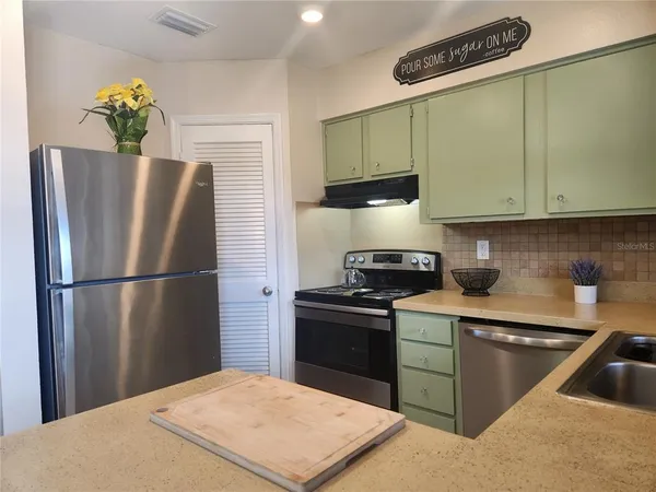 a kitchen with stainless steel appliances granite countertop a refrigerator sink and stove