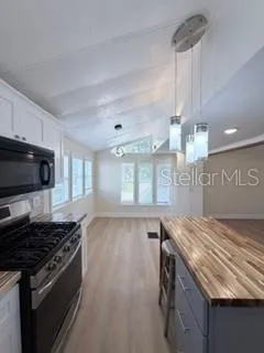 a kitchen with stainless steel appliances granite countertop a stove and a wooden cabinets