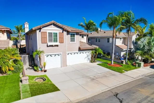 a view of a house with a yard and potted plants