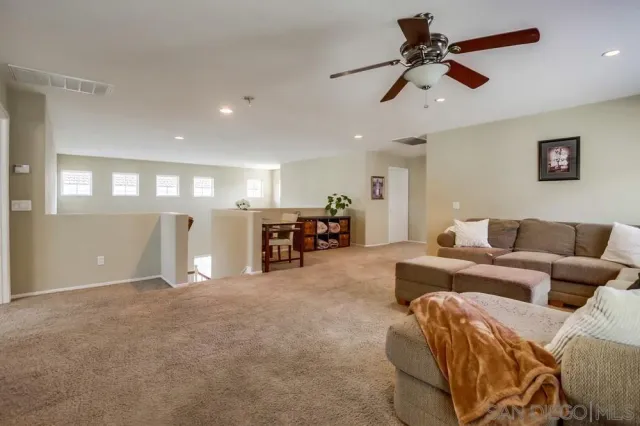 a living room with furniture and a ceiling fan