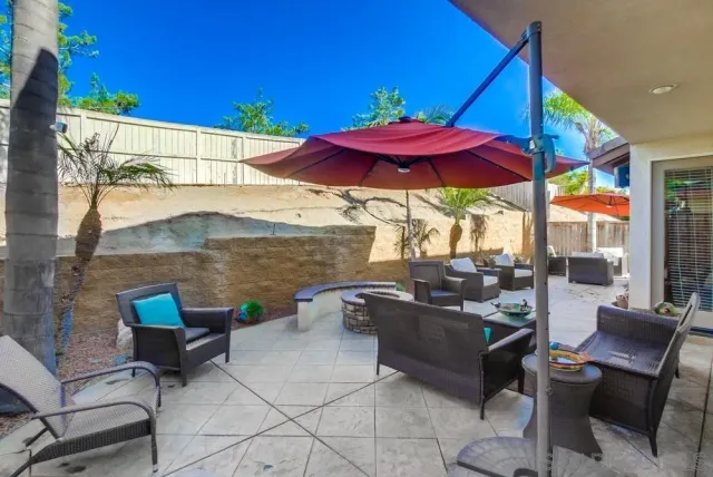 a view of a patio with chairs and a table under an umbrella