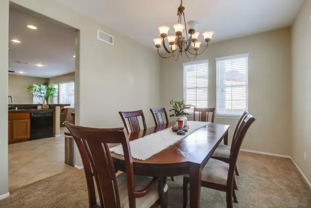 a view of a dining room with furniture and chandelier