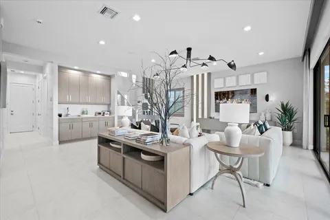 a living room with furniture kitchen view and a large window