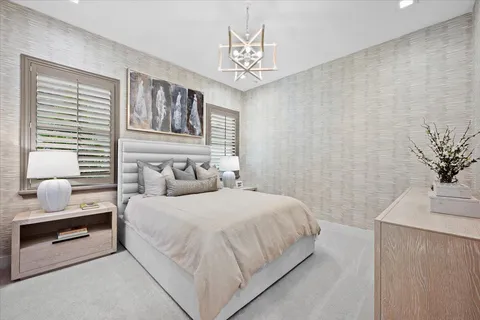 a bedroom with a large bed and a chandelier