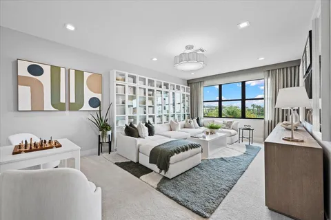 a living room with furniture fireplace and a large window