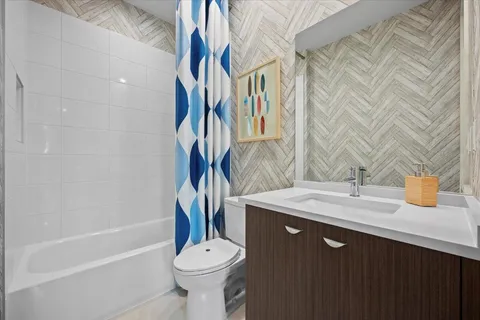 a bathroom with a granite countertop sink toilet and shower