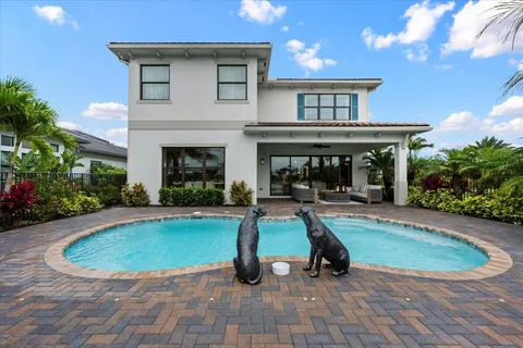 a view of a house with swimming pool and sitting area