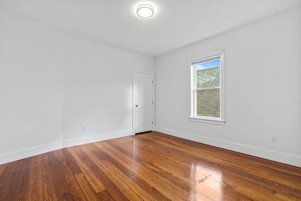 307 Hancock Street, Unit 3 Boston, MA 02125 - Photo 13 of 25 an empty room with wooden floor and windows