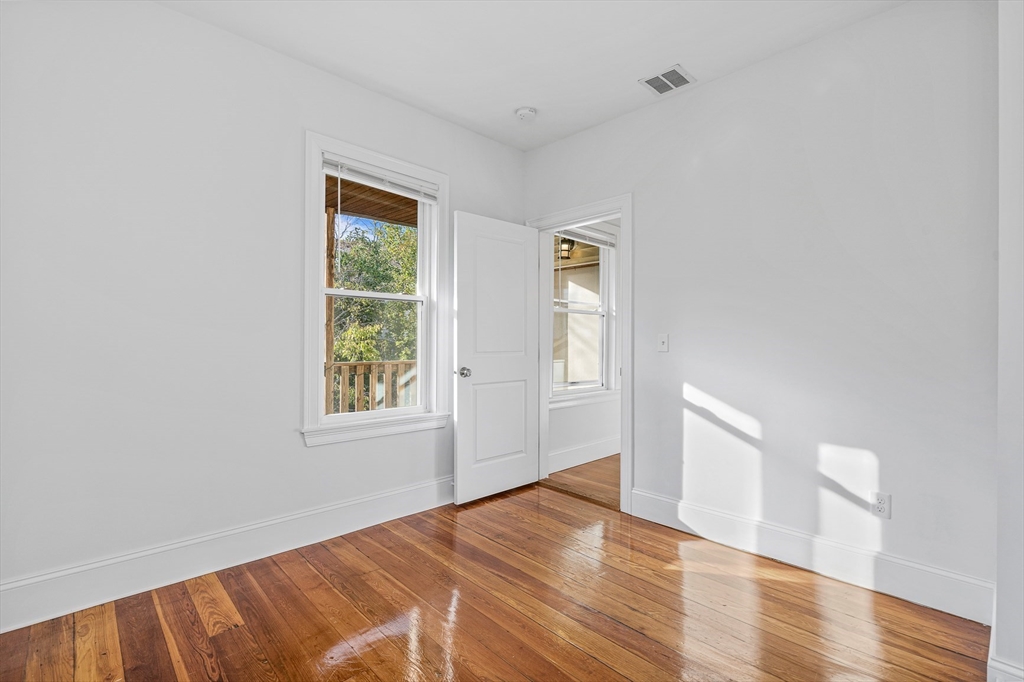 307 Hancock Street, Unit 3 Boston, MA 02125 - Photo 21 of 25 an empty room with wooden floor and windows
