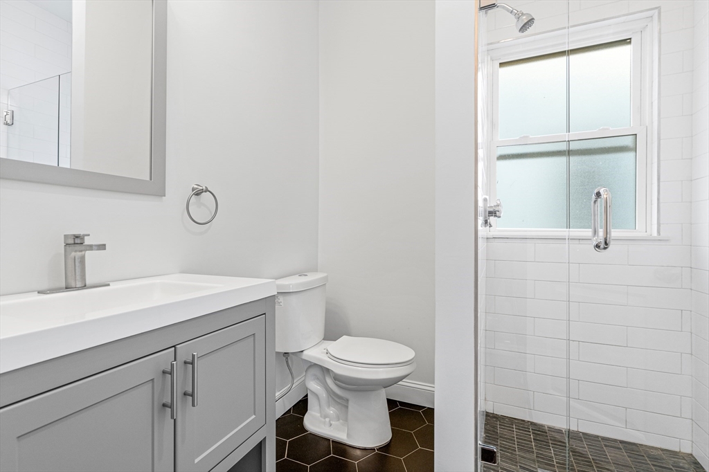 307 Hancock Street, Unit 3 Boston, MA 02125 - Photo 24 of 25 a bathroom with a toilet a sink and a window