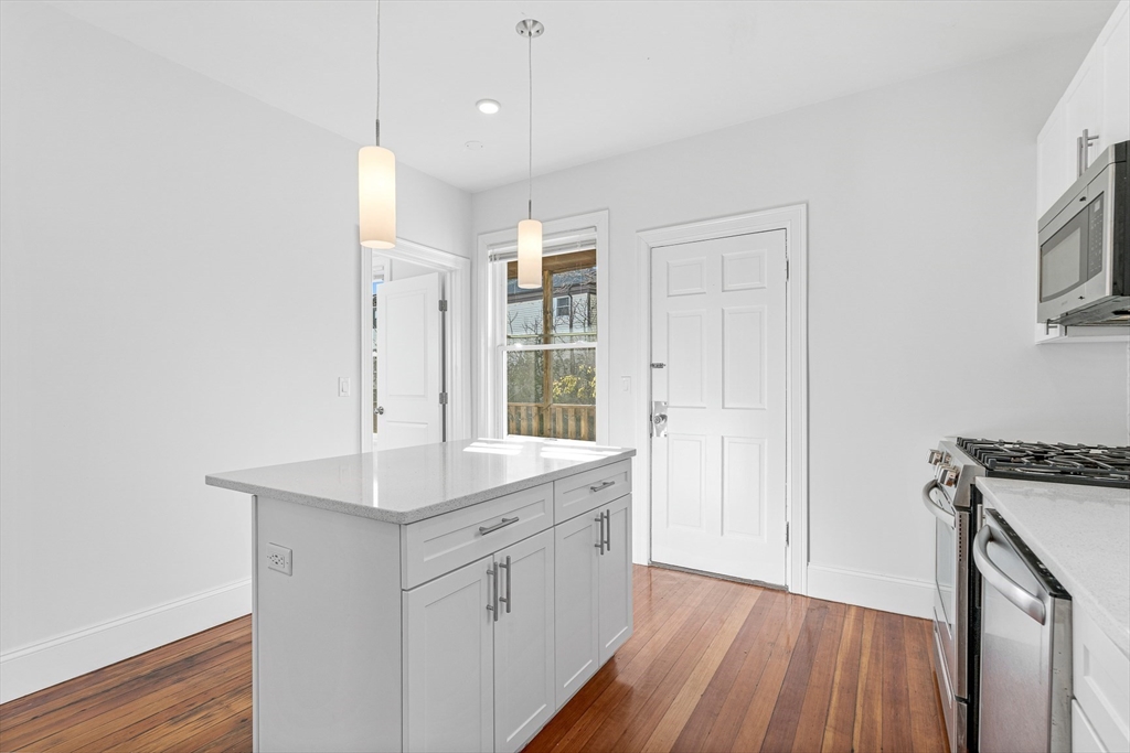 307 Hancock Street, Unit 3 Boston, MA 02125 - Photo 5 of 25 a view of a kitchen with wooden floor and electronic appliances