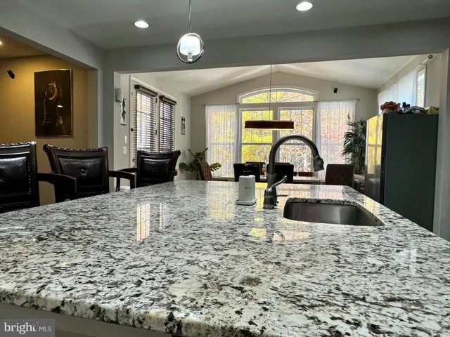 a kitchen with a dining table chairs and refrigerator