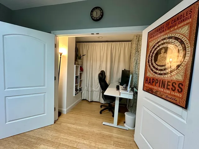 a view of a workspace with furniture and a window